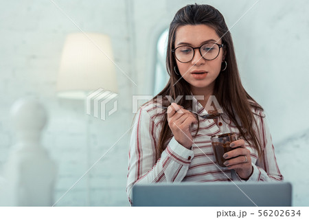 Amazing longhaired woman staring at screen of laptop Amazing longhaired woman staring at screen of laptop 56202634
