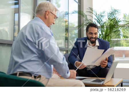 Positive delighted men working together in business center 56218269