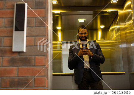 Cheerful young man staring at his telephone 56218639
