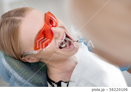 Planned dental examination of young cheerful woman. 56220106
