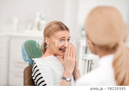 Dentists patient being happy having new braces. Dentists patient being happy having new braces. 56220395