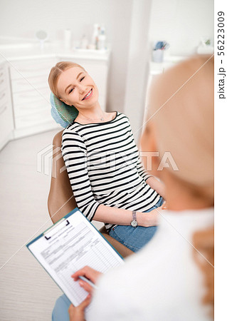 Patient talking to her dentist writing in medication form. 56223009