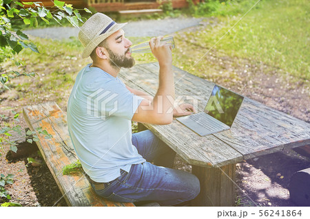 Businessman is working with computer in forest. 56241864