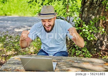 Man rejoices victory looking at digital screen. Man rejoices victory looking at digital screen. 56241865
