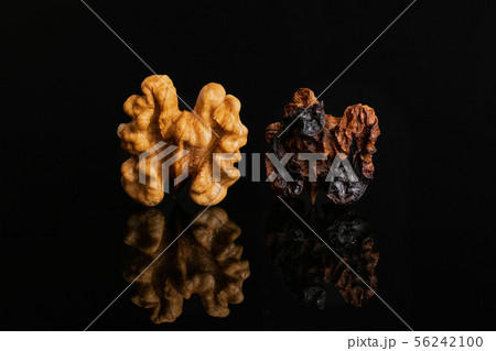Ripe brown walnut isolated on black glass 56242100