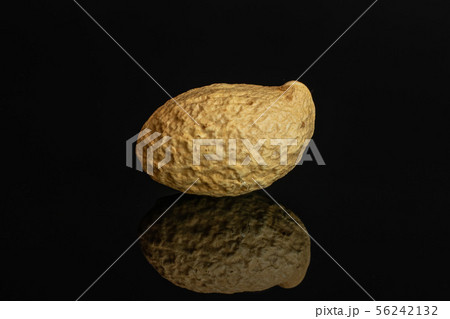 Yellow natural peanut isolated on black glass 56242132
