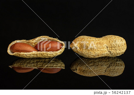 Yellow natural peanut isolated on black glass 56242137