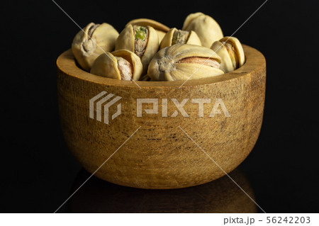 Green salted pistachio isolated on black glass 56242203