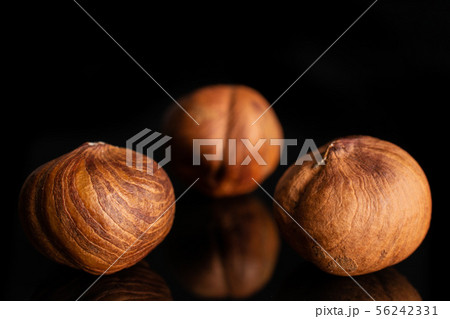 Ripe brown hazelnut isolated on black glass 56242331