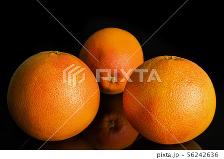 Fresh pink grapefruit isolated on black glass Fresh pink grapefruit isolated on black glass 56242636