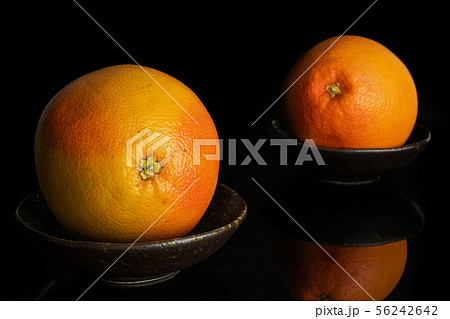 Fresh pink grapefruit isolated on black glass Fresh pink grapefruit isolated on black glass 56242642