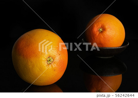 Fresh pink grapefruit isolated on black glass Fresh pink grapefruit isolated on black glass 56242644