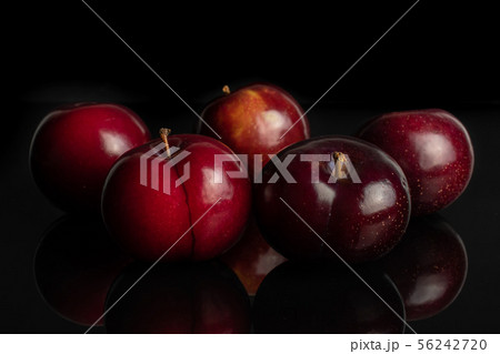 Ripe red plum isolated on black glass Ripe red plum isolated on black glass 56242720