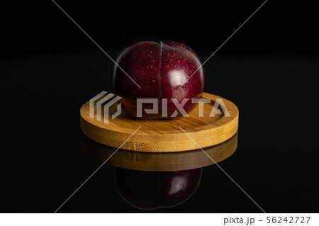 Ripe red plum isolated on black glass Ripe red plum isolated on black glass 56242727
