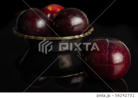 Ripe red plum isolated on black glass Ripe red plum isolated on black glass 56242731