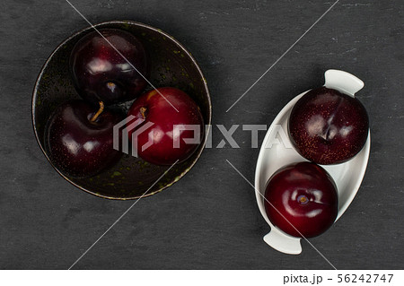 Ripe red plum on grey stone Ripe red plum on grey stone 56242747