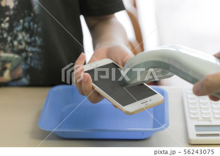 スマートフォンでQRコード決済する女性 56243075