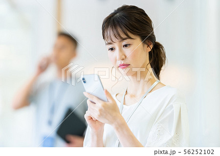 女性社員　スマホで会話　ビジネスイメージ 56252102