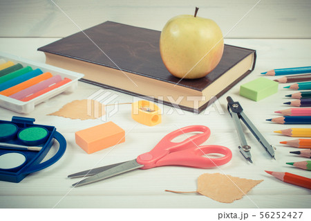 Book, school accessories and autumnal leaves 56252427