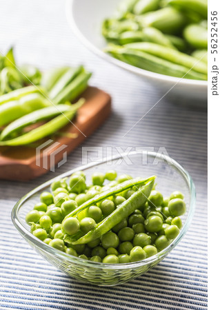 Fresh green pea seeds in bowl on kitchen table Fresh green pea seeds in bowl on kitchen table 56252456