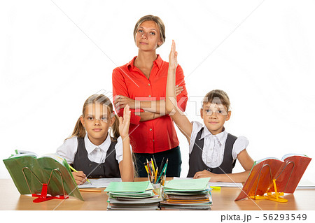 Children pull their hands up, ready to answer a 56293549