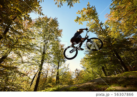 Professional sportsman cyclist jump on trial bike on boulder 56307866