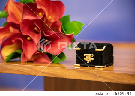 Box with wedding rings and bouquet of red flowers Box with wedding rings and bouquet of red flowers 56309594