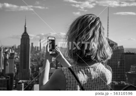 Blonde tourist taking a picture of the Empire Blonde tourist taking a picture of the Empire 56310596