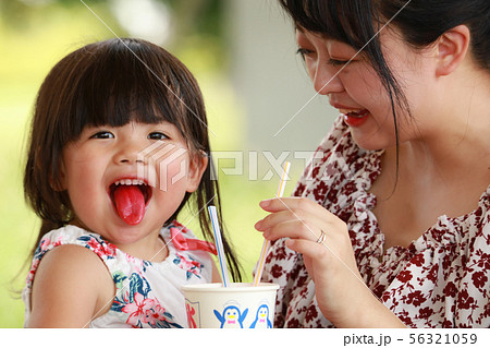 かき氷を食べて舌が赤くなる女の子の写真素材