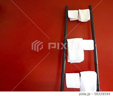 White towels hanging on rustic wooden ladder White towels hanging on rustic wooden ladder 56328594