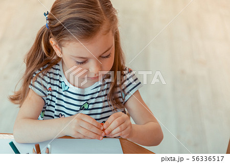 Nice cute girl holding a piece of modeling clay Nice cute girl holding a piece of modeling clay 56336517