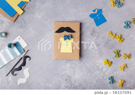 Making greeting card for Fathers Day. Shirt with butterfly from pasta. Card from paper. moustache 56337091