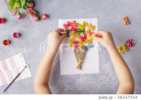 Paper crafts for mother day, 8 march or birthday. Small child doing a bouquet of flowers out of 56337554