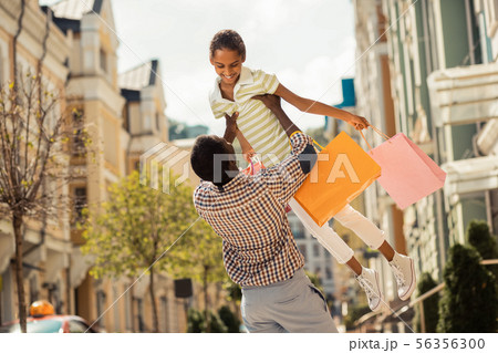 Cheerful little female feeling happiness during family walk 56356300