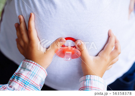 Pregnant woman and her young daughter's hands Pregnant woman and her young daughter's hands 56358378