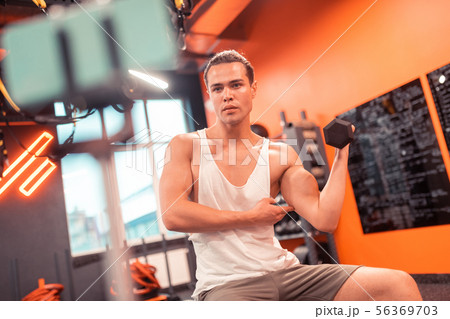 Serious good looking man showing his muscles on camera 56369703