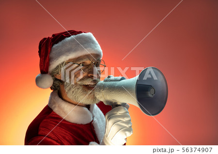 Senior Santa Claus holding loud speaker in hands Senior Santa Claus holding loud speaker in hands 56374907