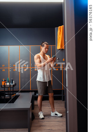 Attractive fit man typing a message on the smartphone Attractive fit man typing a message on the smartphone 56376165