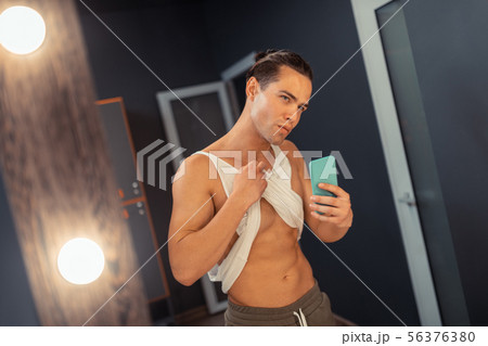 Attractive fit man taking a photo in the mirror Attractive fit man taking a photo in the mirror 56376380