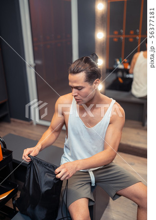 Pleasant serious man looking into his bag Pleasant serious man looking into his bag 56377181