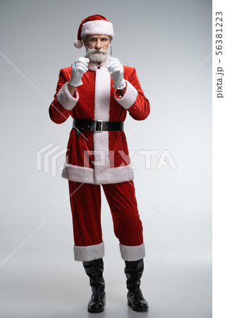 Calm senior Santa Claus standing in costume Calm senior Santa Claus standing in costume 56381223