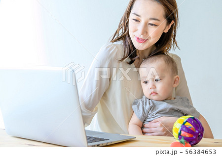 子供を抱きながらパソコンを操作する女性 56384653