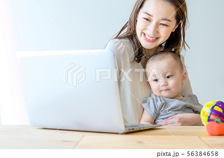 子供を抱きながらパソコンを操作する女性 56384658