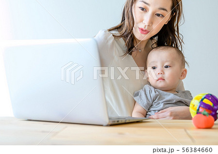 子供を抱きながらパソコンを操作する女性 56384660