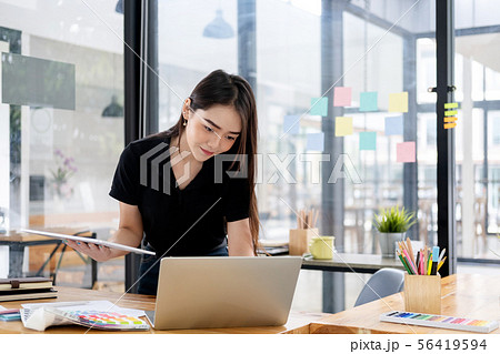 Graphic designer working at her desk in creative Graphic designer working at her desk in creative 56419594