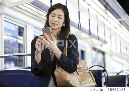 通勤電車でスマートフォンを操作するビジネスウーマン 通勤電車でスマートフォンを操作するビジネスウーマン 56452143