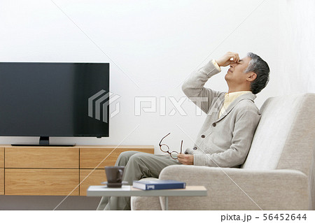 眉間を押さえる中高年男性 眉間を押さえる中高年男性 56452644