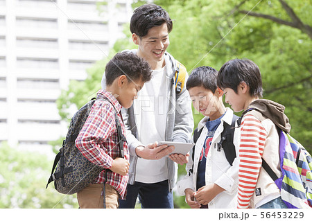 タブレットPCを見る小学生と先生 56453229