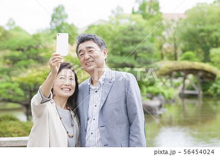 スマートフォンで写真を撮る中高年夫婦 56454024