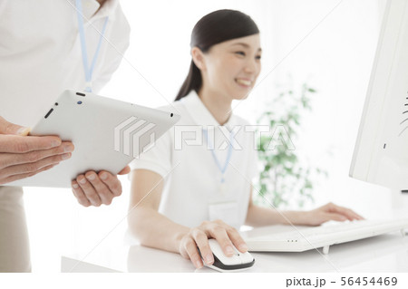 パソコンを操作する女性とタブレットPCを持つ男性 56454469